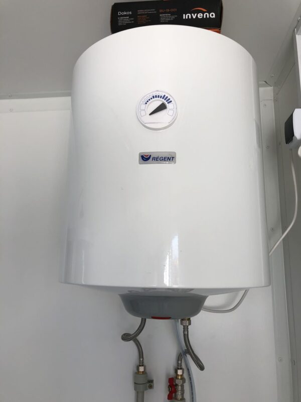 Contentor sanitário com chuveiro, lavatório e sanita.